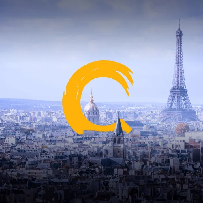 The rooftops of Paris and the Eiffel Tower under a hazy sky, behind a large yellow brush-painted C.